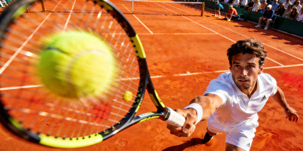 网球运动员在红土场地上击球